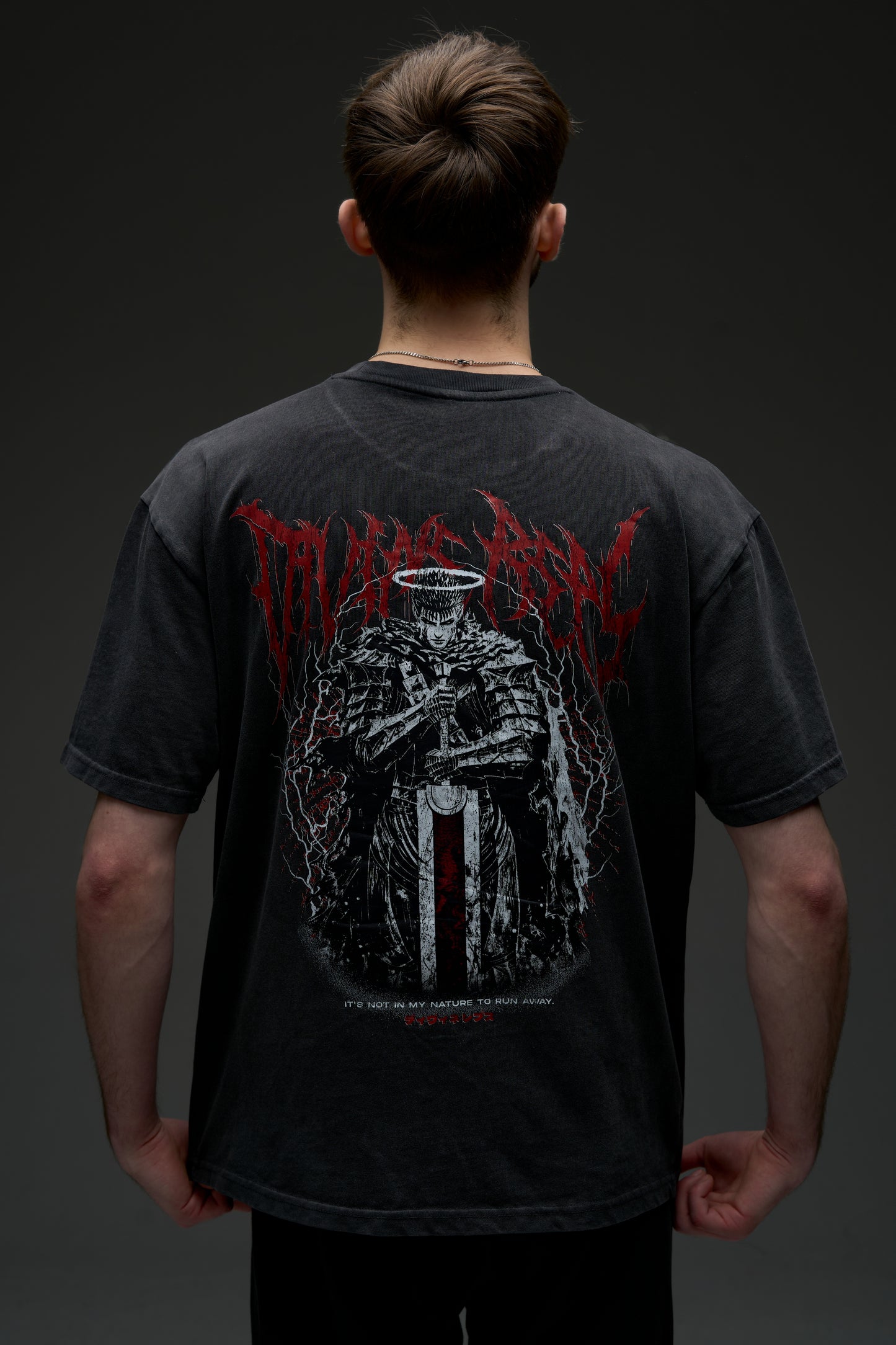Model wearing the washed black Guts Dark Edition tee - back view with large armored warrior print