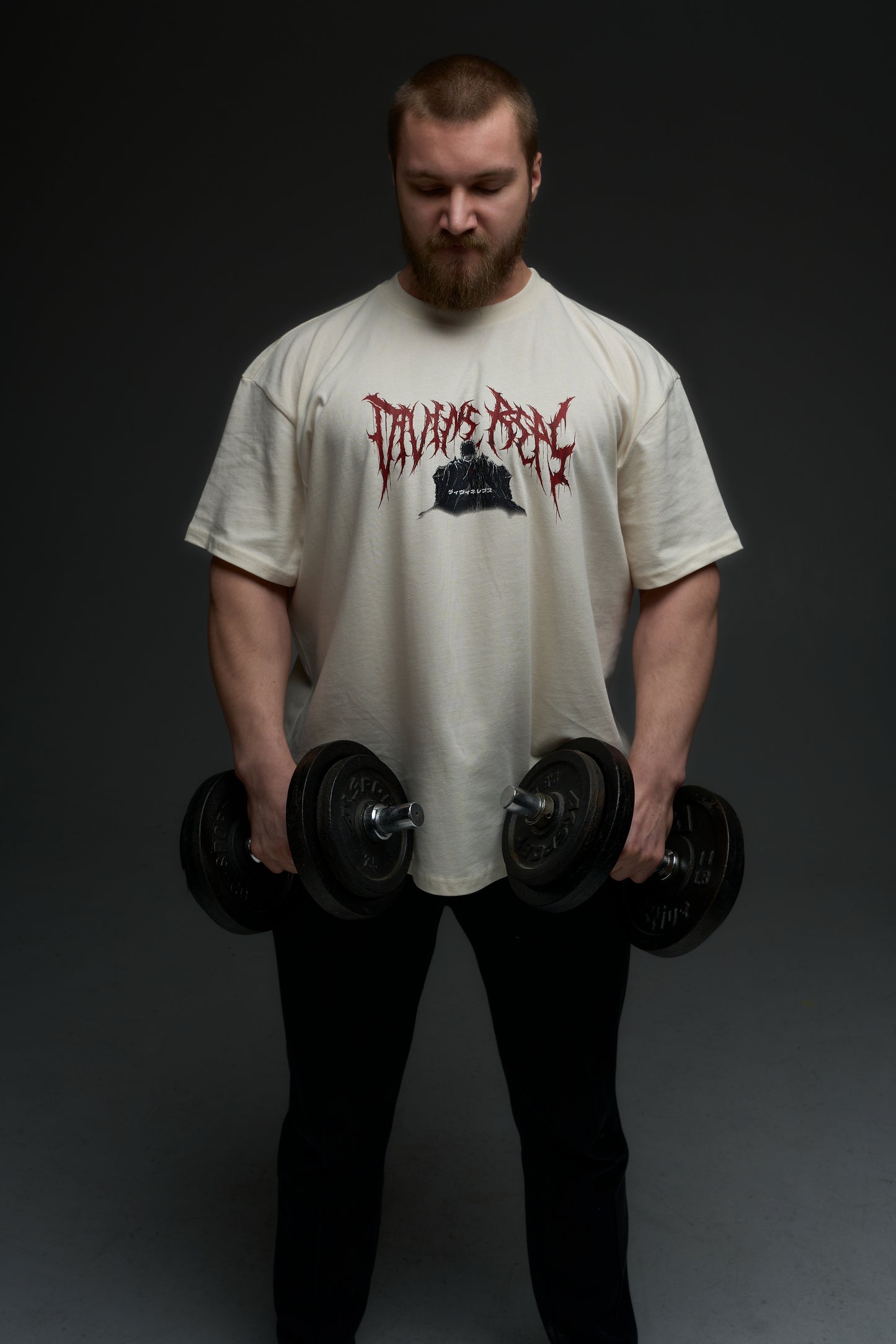 Model holding dumbbells in the natural raw Guts armor tee - front view with red Divine Reps chest logo