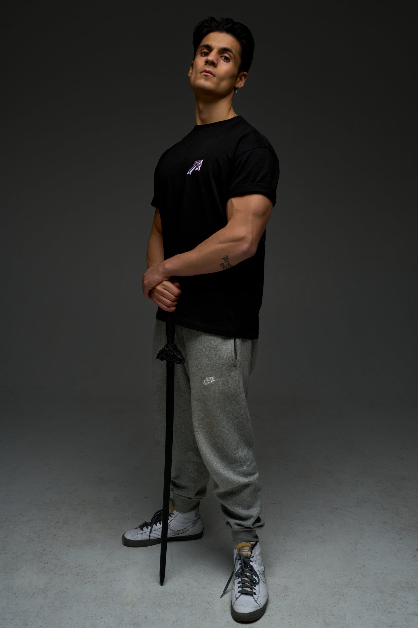 Model wearing the black Sung Jinwoo armor tee - front view with small purple chest print
