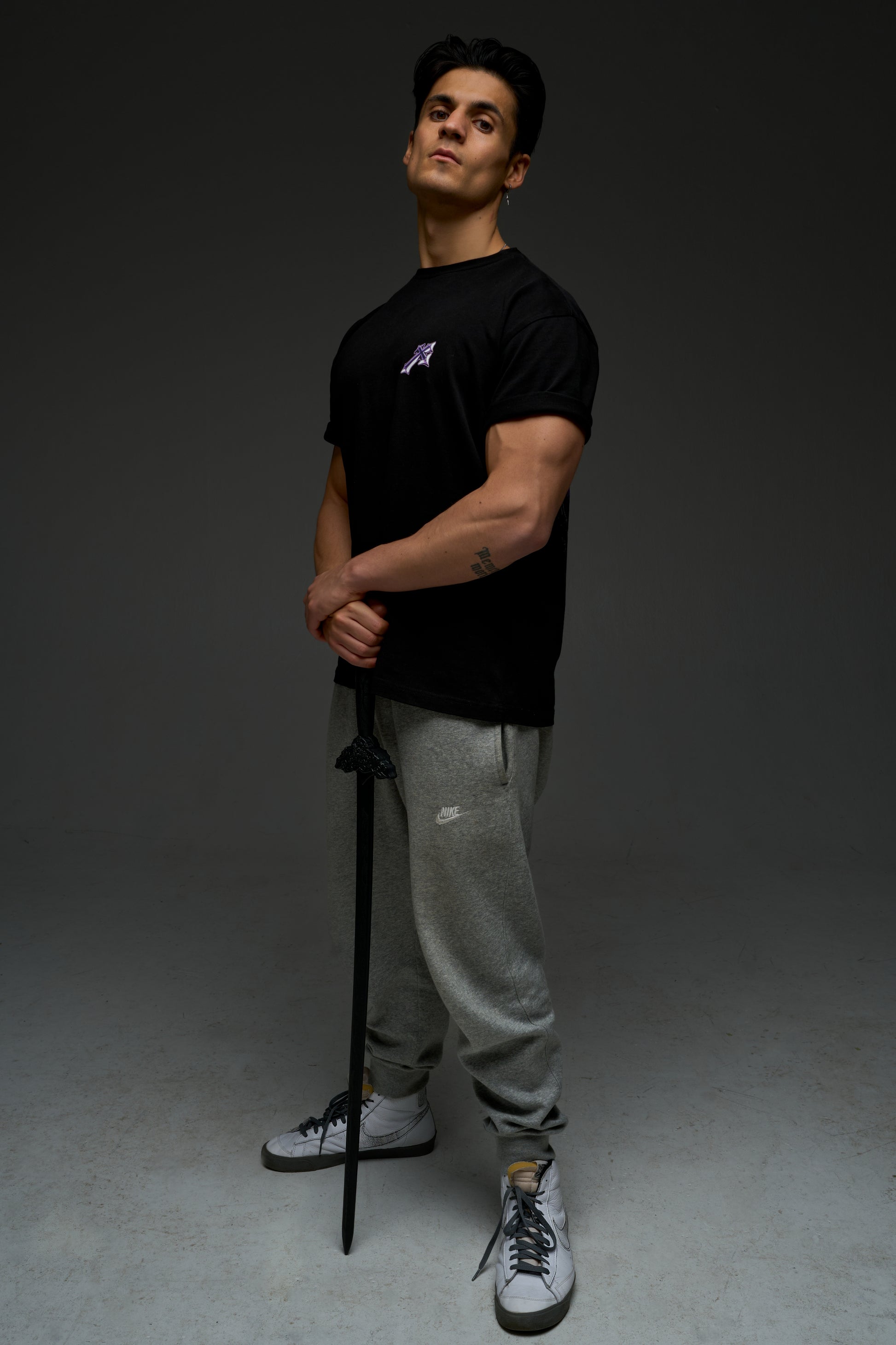 Model wearing the black Sung Jinwoo armor tee - front view with small purple chest print